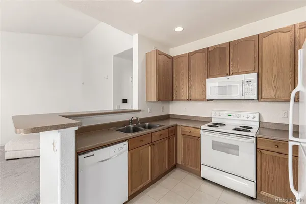 a kitchen with granite countertop cabinets and white stove