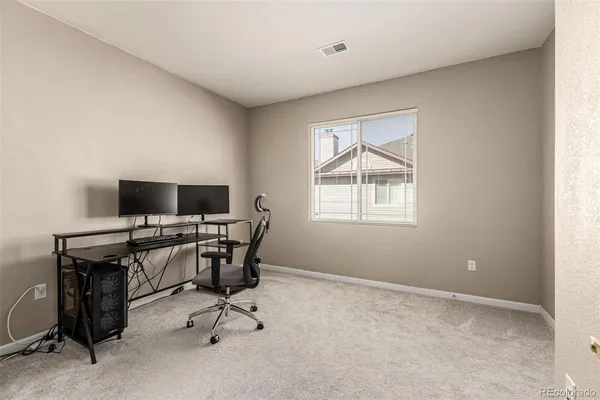 a view of a workspace with furniture and a window