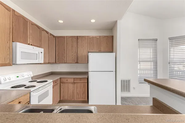 a kitchen with a stove a refrigerator and a sink