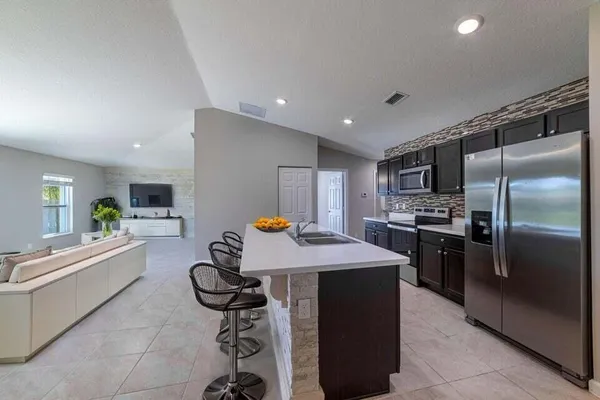 a kitchen with a refrigerator a sink dishwasher and a stove with wooden floor