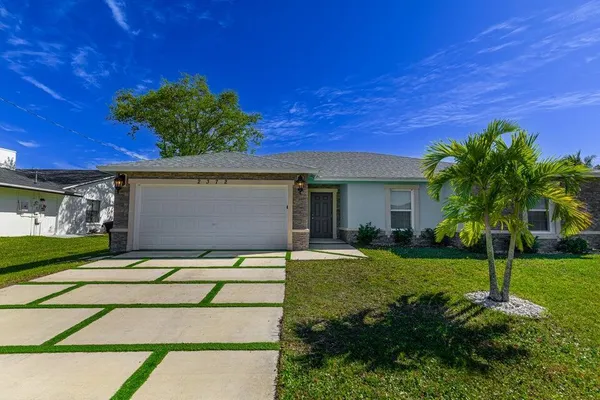 a view of a house with backyard and a tree