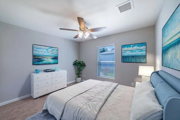 an empty room with windows and fan