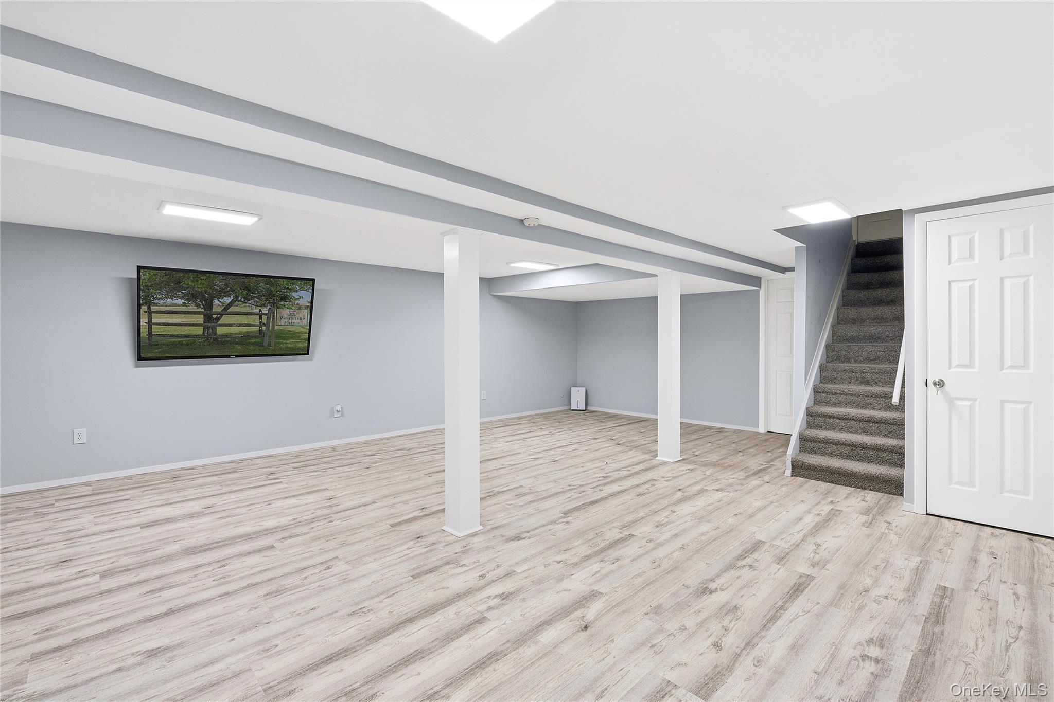 122 Beach Road Westhampton Beach, NY 11978 - Photo 16 of 18 a view of an empty room with wooden floor and stairs