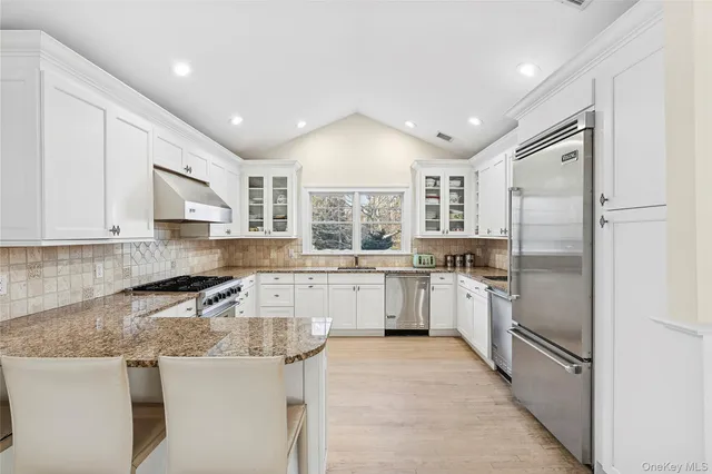 a kitchen with a sink a refrigerator and cabinets