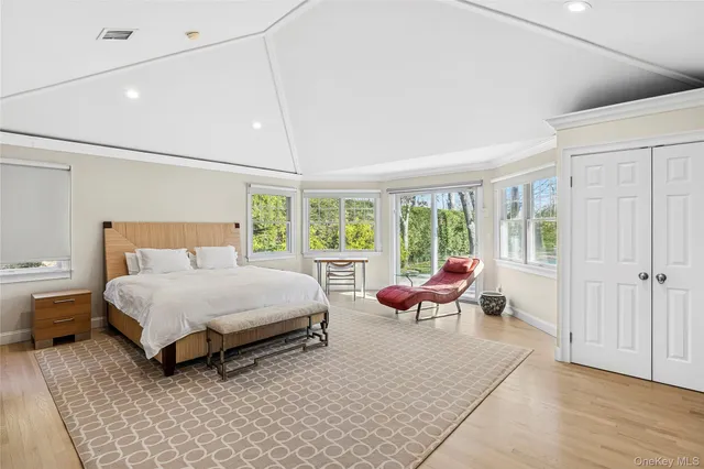 a spacious bedroom with a bed and large windows