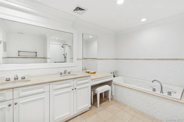 a bathroom with a tub sink and mirror