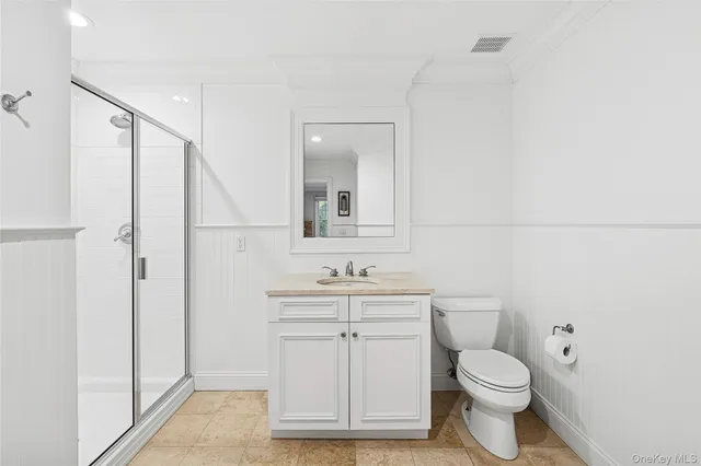 a bathroom with a toilet sink a mirror and vanity