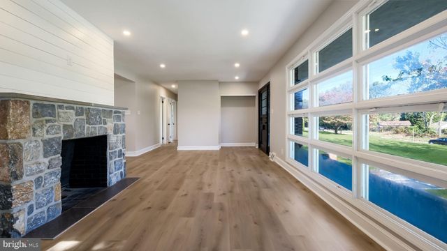 a view of an empty room with a fireplace and a window