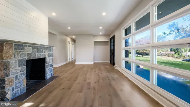 a view of an empty room with a fireplace and a window