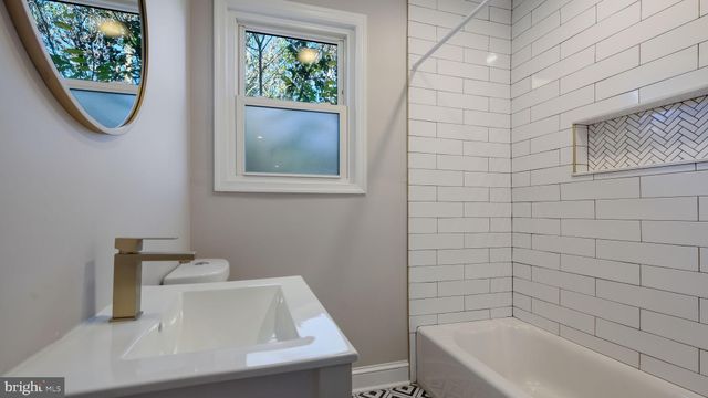 a bathroom with a sink a window and a bathtub