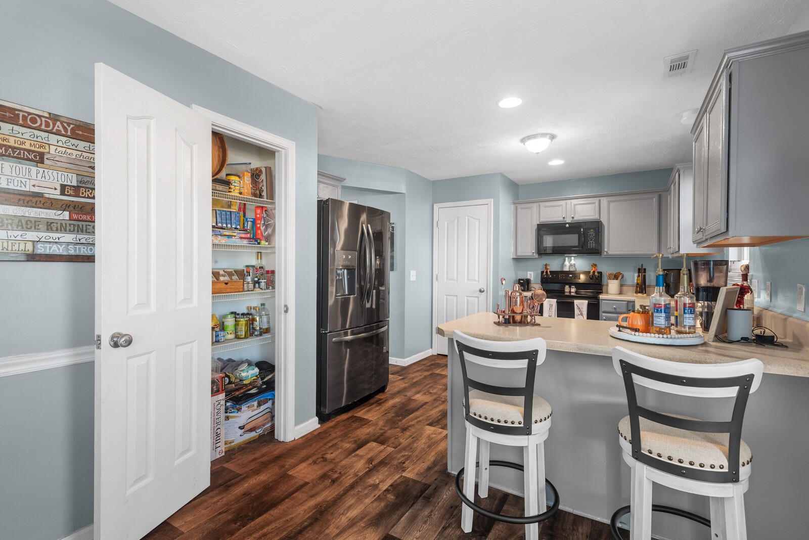 1413 Fall Parkway Murfreesboro, TN 37129 - Photo 2 of 48 a kitchen with a refrigerator a stove a dining table and chairs with wooden floor