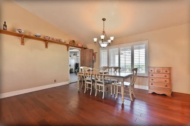 a bed sitting in a spacious bedroom next to a large window with a chandelier fan
