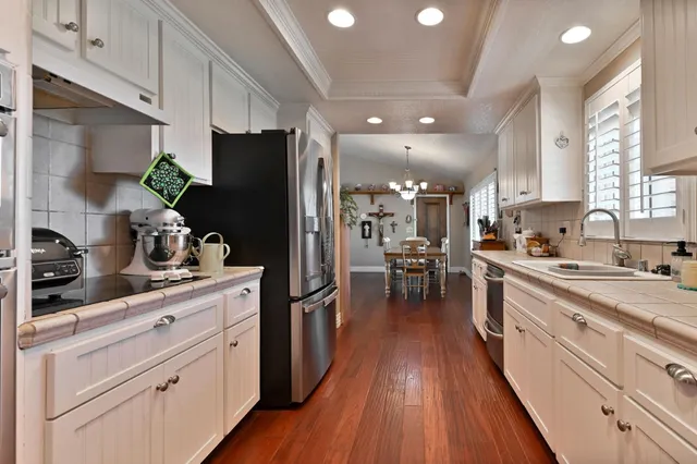 a kitchen with granite countertop white cabinets and white appliances