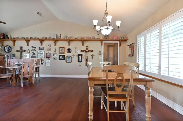 a view of a dining room and livingroom with furniture wooden floor a chandelier