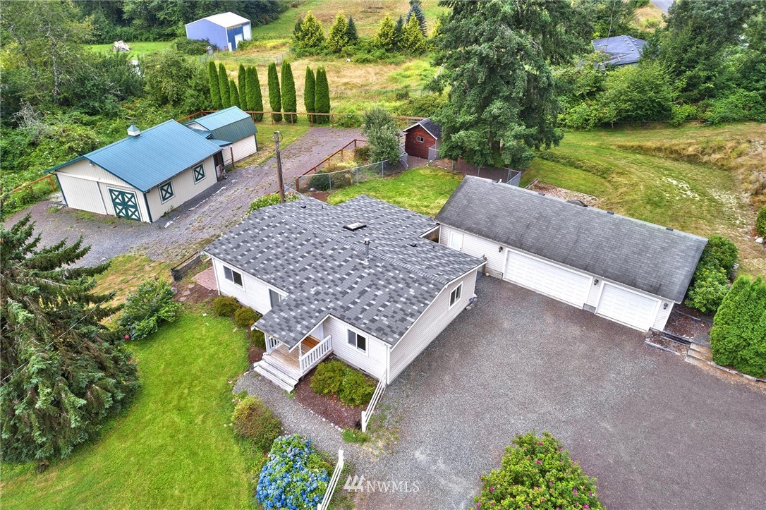 an aerial view of a house with garden space and a patio