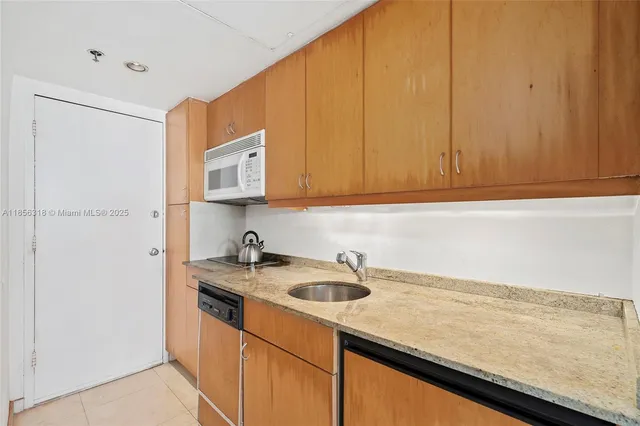 a kitchen with a sink cabinets and a microwave