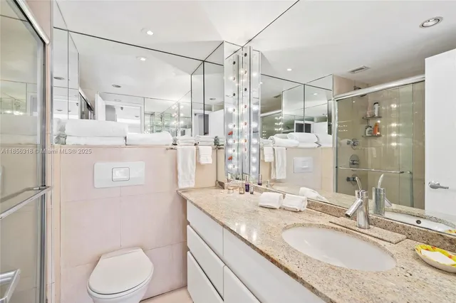 a bathroom with a granite countertop sink toilet and shower