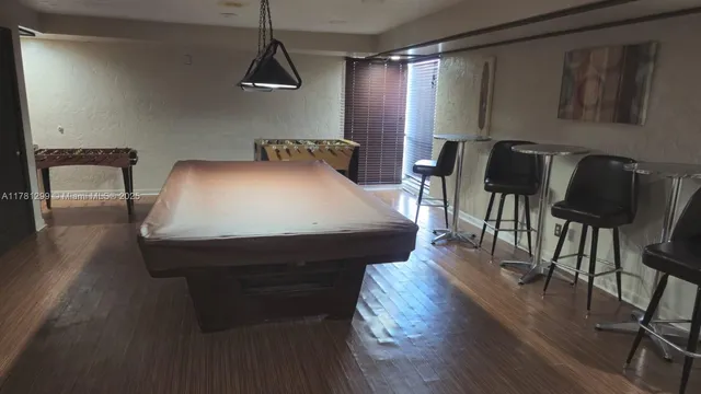 a bed sitting in a bedroom next to a window with wooden floor