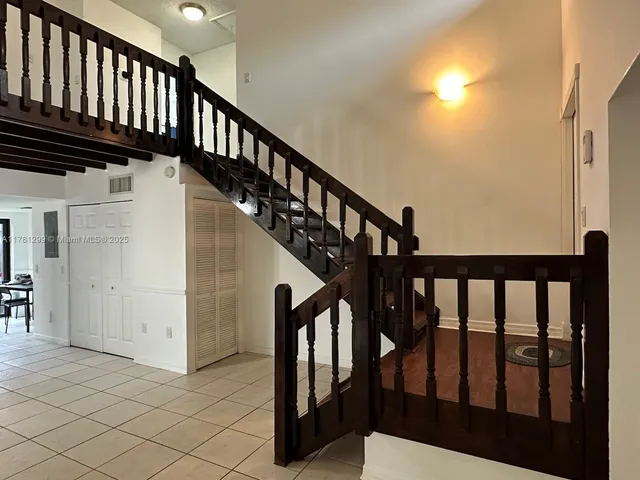 a view of staircase with lots of frames on wall and a window