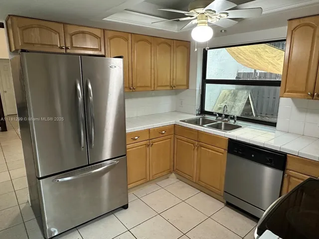 a kitchen with a refrigerator a sink and cabinets