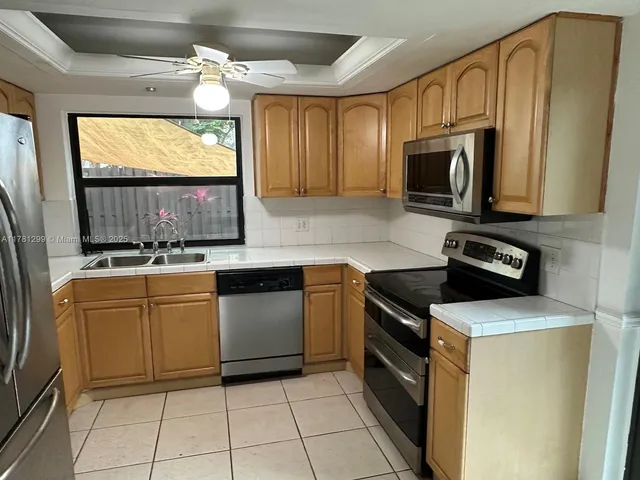a kitchen with granite countertop cabinets stainless steel appliances and a window