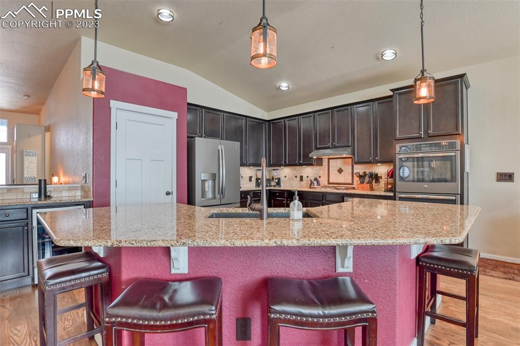 9785 Terrain Road Fountain, CO 80817 - Photo 11 of 40 a kitchen with stainless steel appliances granite countertop a stove top oven a refrigerator a sink and chairs