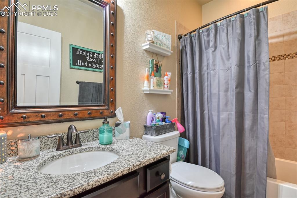 9785 Terrain Road Fountain, CO 80817 - Photo 20 of 40 a bathroom with a granite countertop sink a toilet and a mirror