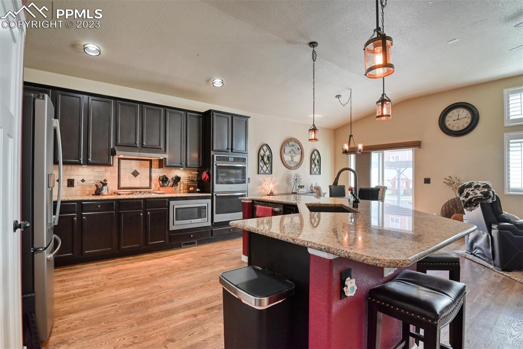 9785 Terrain Road Fountain, CO 80817 - Photo 10 of 40 a kitchen with kitchen island granite countertop a stove refrigerator and cabinets