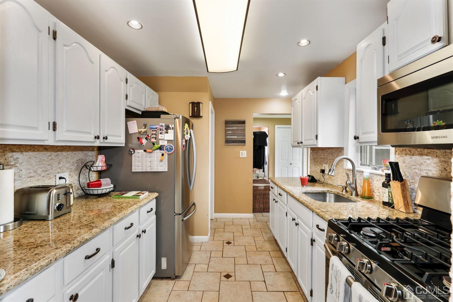 13 Edgewood Road Linden, NJ 07036 - Photo 7 of 14 a kitchen with stainless steel appliances granite countertop a stove a sink and a refrigerator