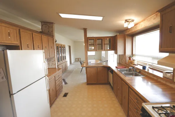 a kitchen with a refrigerator a sink and dishwasher with a large window