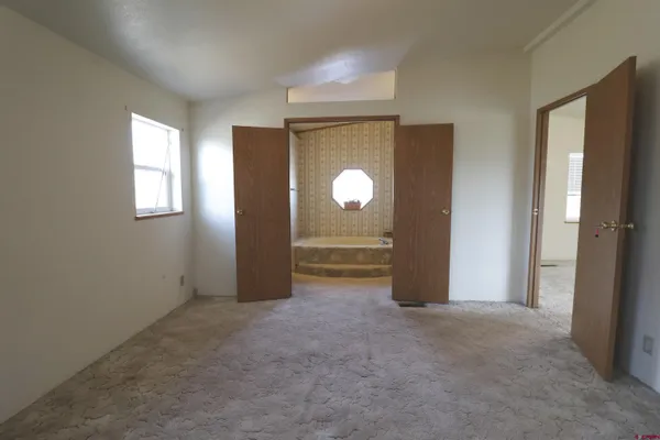an empty room with windows and closet