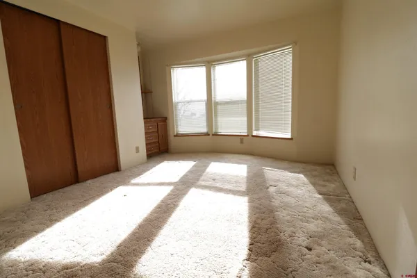 a view of a bedroom with wooden floor and a window