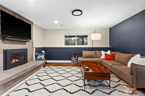 a living room with furniture a flat screen tv and a fireplace