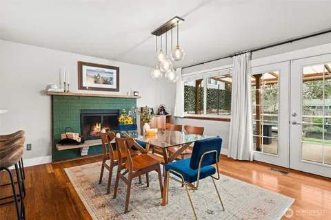 a dining room with furniture a fireplace and wooden floor