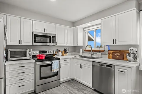 a kitchen with stainless steel appliances granite countertop a sink stove oven and microwave