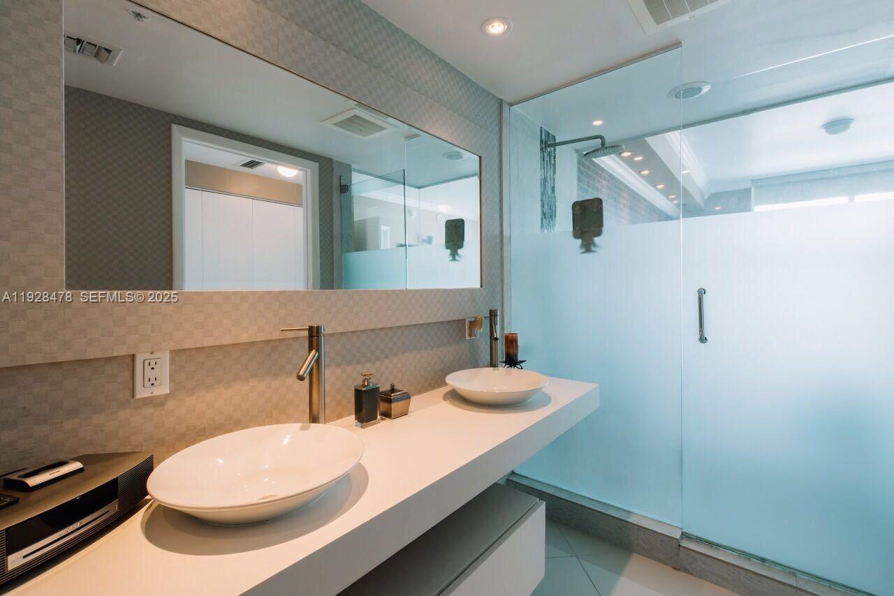 92 Southwest 3rd Street, Unit 1512 Miami, FL 33130 - Photo 11 of 15 a bathroom with a sink and a mirror