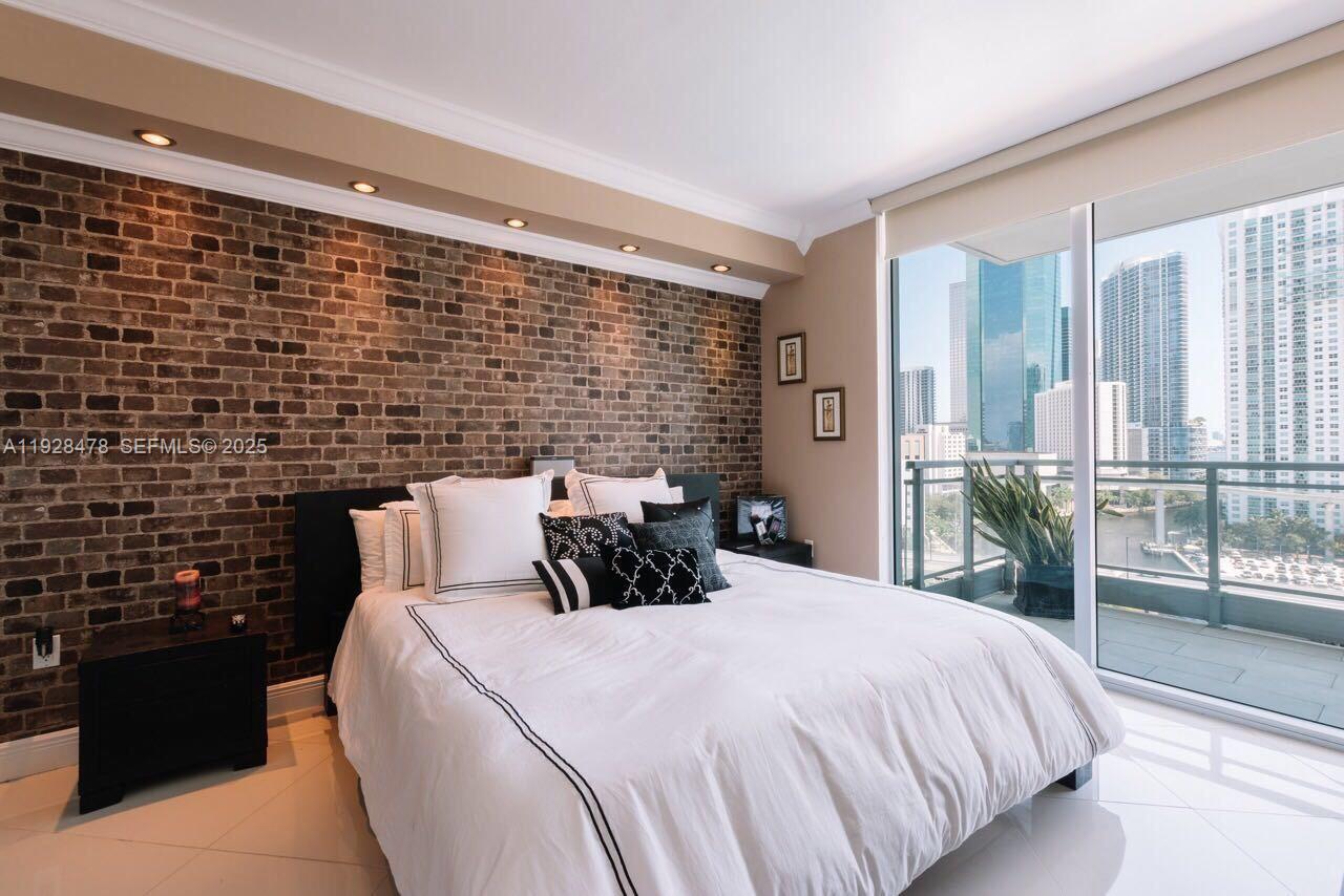 92 Southwest 3rd Street, Unit 1512 Miami, FL 33130 - Photo 13 of 15 a bed sitting in a bedroom next to a window