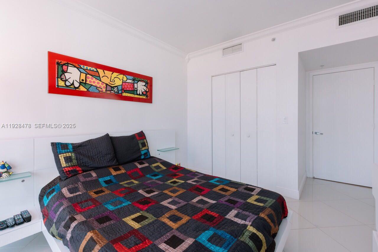 92 Southwest 3rd Street, Unit 1512 Miami, FL 33130 - Photo 14 of 15 a bedroom with a bed and a lamp on dresser