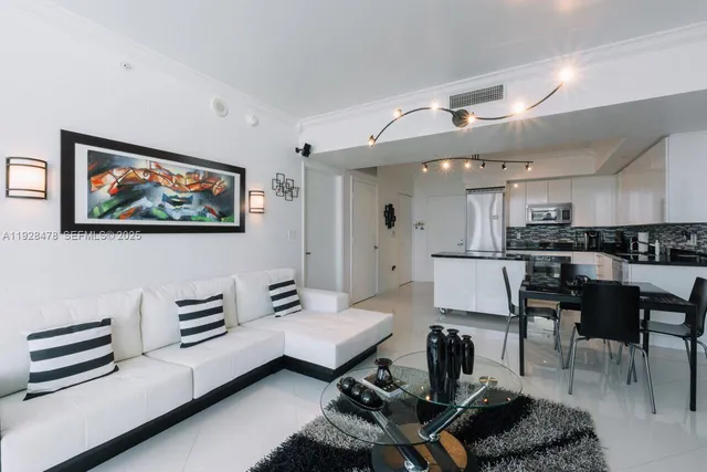 a living room with furniture and kitchen view