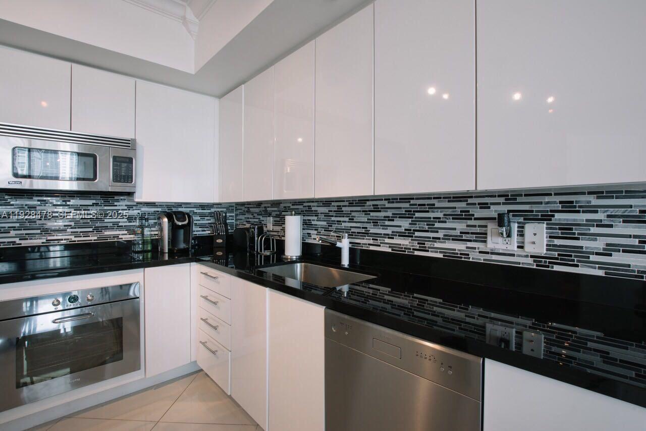 92 Southwest 3rd Street, Unit 1512 Miami, FL 33130 - Photo 7 of 15 a kitchen with sink a stove and cabinets
