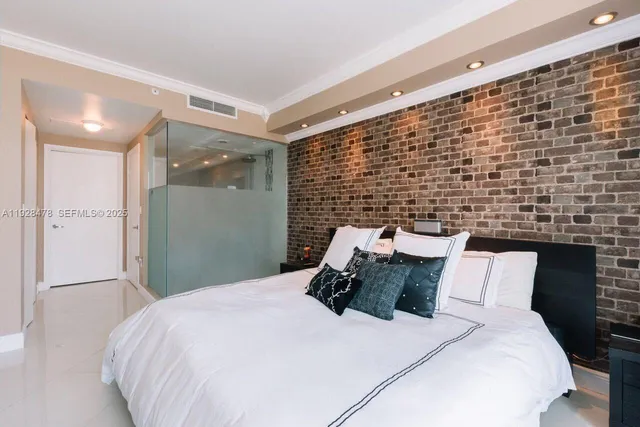 a bed sitting in a bedroom next to a bathroom