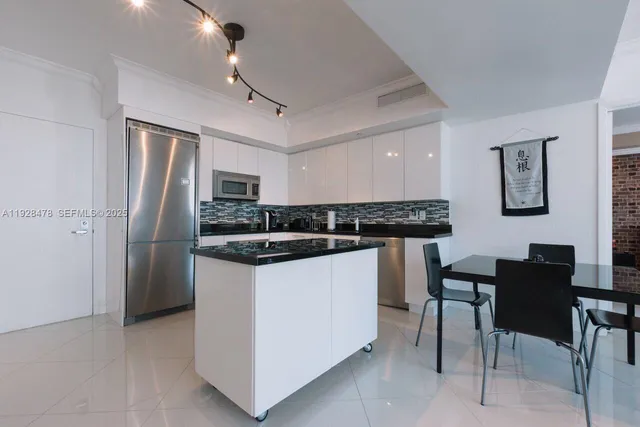 a kitchen with stainless steel appliances granite countertop a refrigerator and a stove top oven