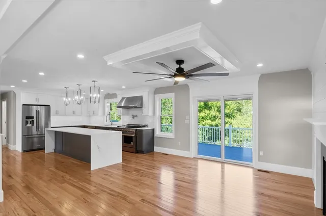 a large kitchen with kitchen island a large counter top space a sink stainless steel appliances and cabinets