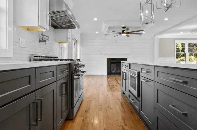 a kitchen with kitchen island a stove a sink and wooden floor