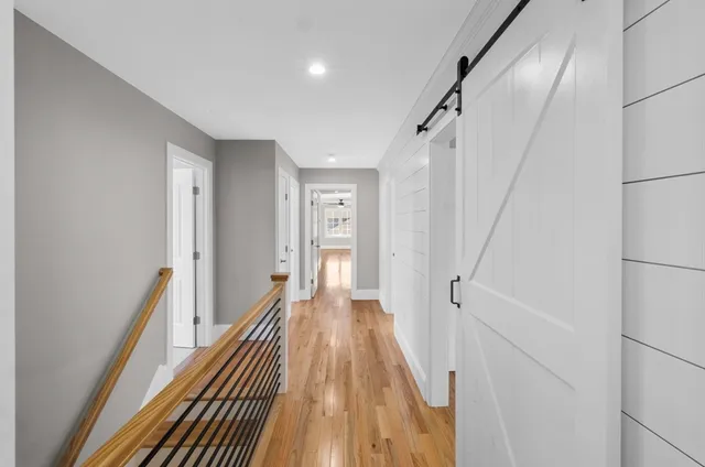 a view of a hallway with wooden floor and staircase