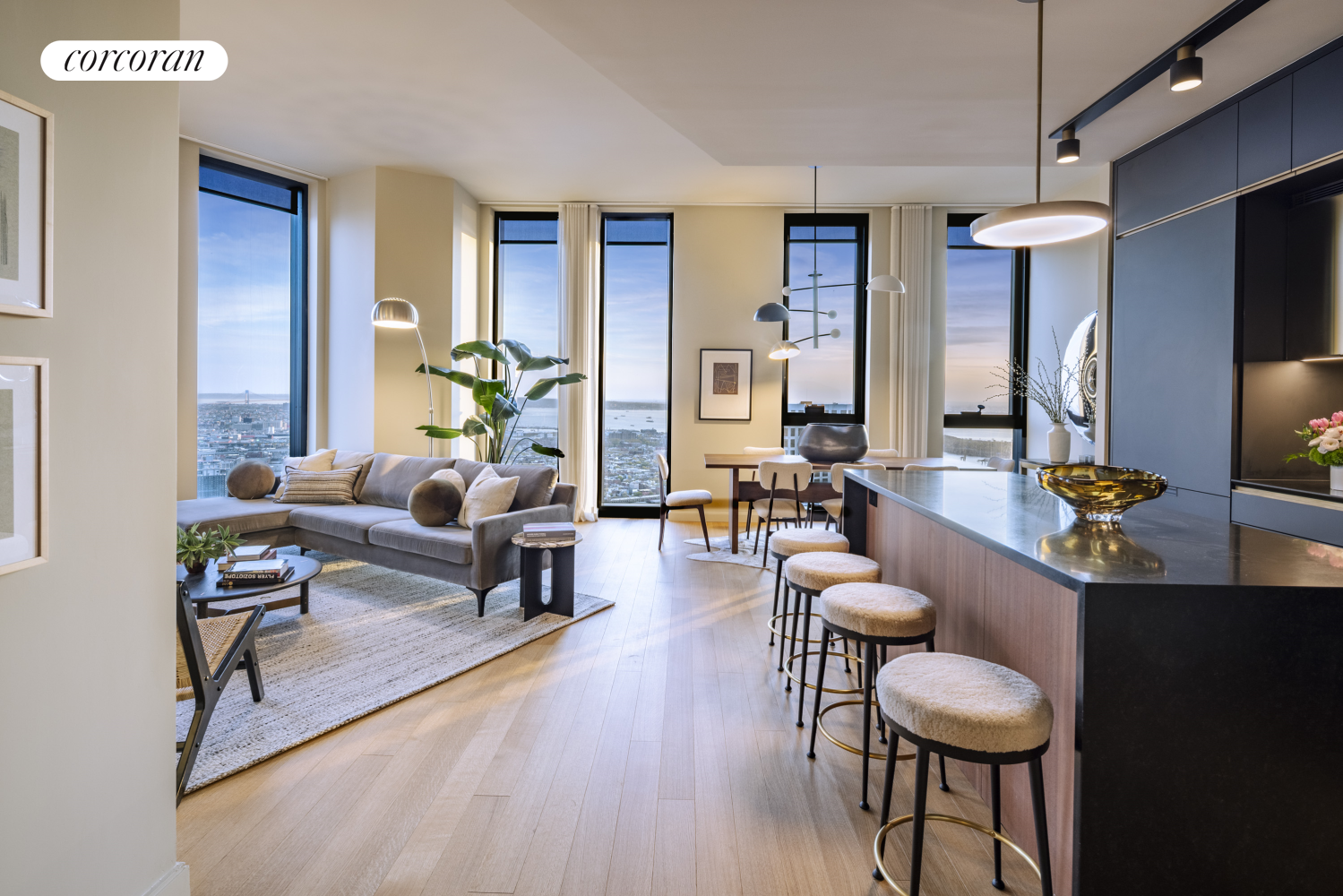 a living room with furniture kitchen view and a wooden floor
