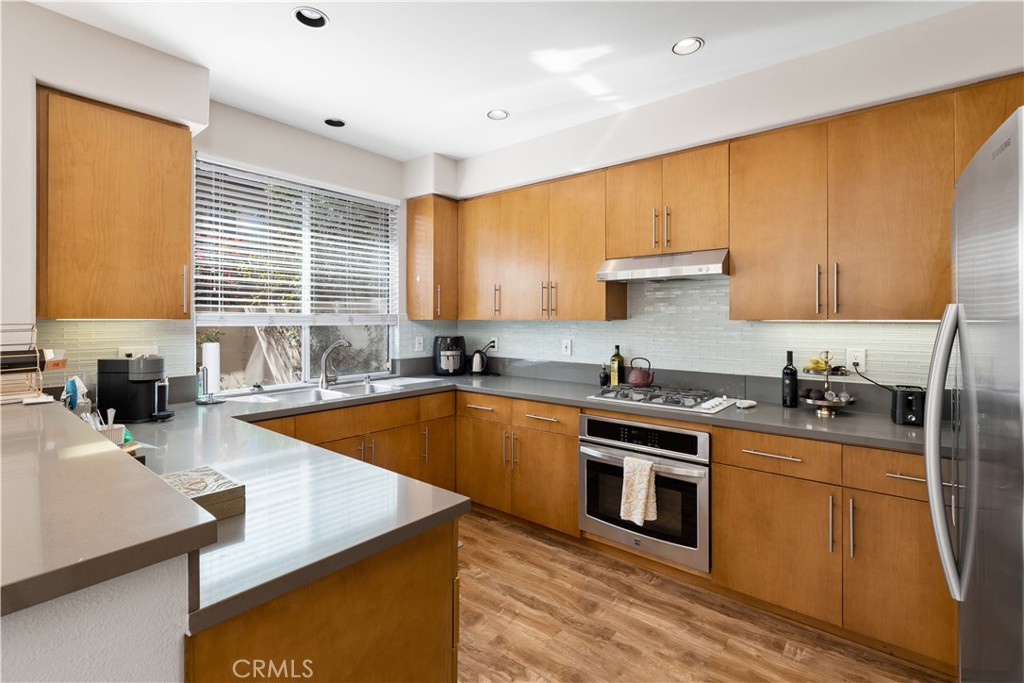 110 Lessay Newport Coast, CA 92657 - Photo 3 of 51 a kitchen with stainless steel appliances granite countertop a sink a stove and a refrigerator