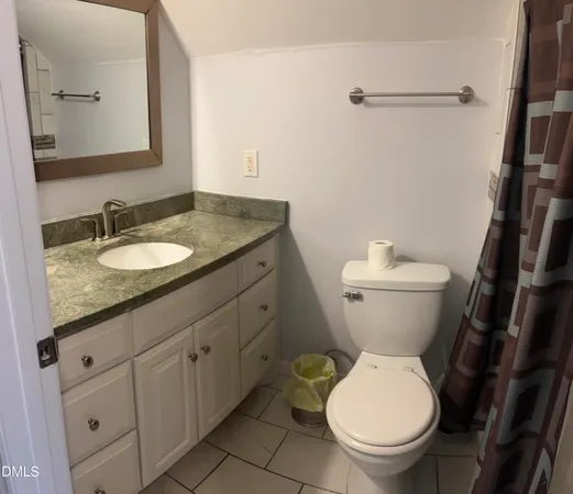 a bathroom with a granite countertop toilet a mirror and a sink