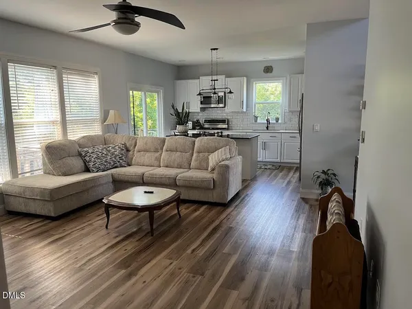 a living room with furniture and a wooden floor