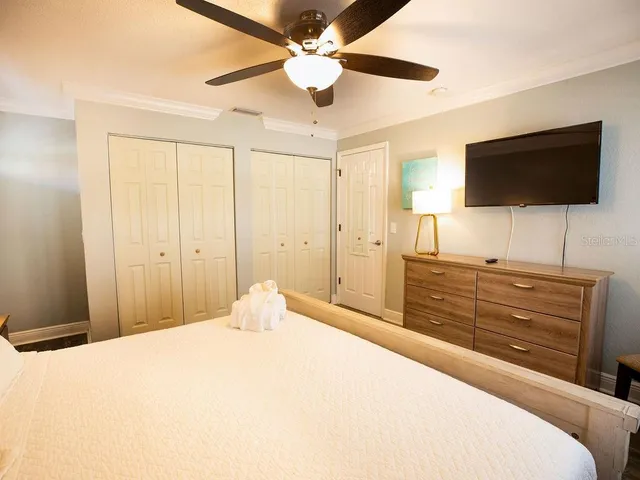 a bedroom with a bed and a flat screen tv